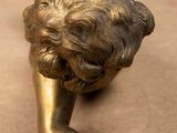 a bronze statue of a child laying on a table