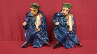 deux figurines représentant un homme et une femme assis sur une surface rouge