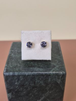 a pair of blue sapphire earrings sitting on top of a marble block
