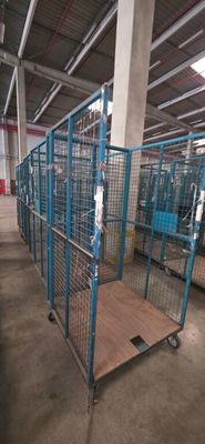 a large metal cage with a wooden floor in a warehouse