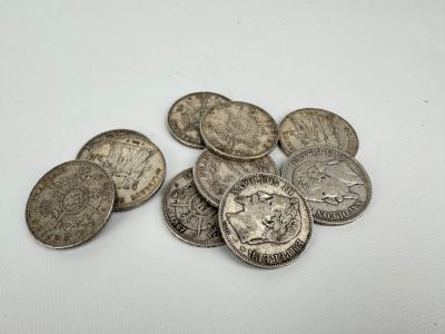 a pile of silver coins sitting on top of a white surface