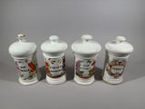 three white ceramic jars with floral designs on them sitting on a table