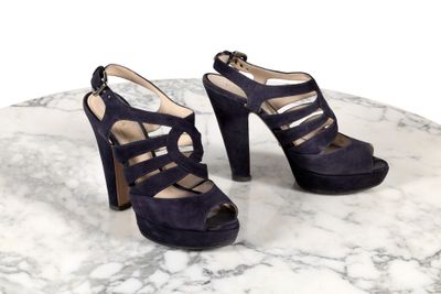 Les chaussures sont posées sur une table en marbre dont le plateau est également en marbre.