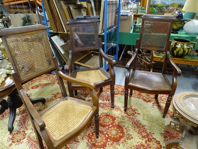 Trois fauteuils de coiffeurs dont deux assise cannée, à dossier à...