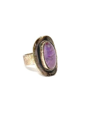 Gros plan sur une bague contenant une pierre violette