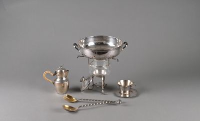 une coupe en argent et d'autres objets en argent posés sur une table