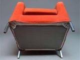an orange and grey chair with a metal frame on a gray surface
