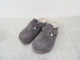 chaussons gris en velours à boucles sur fond blanc