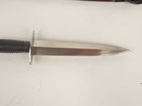 a knife that is laying on a table next to a pair of scissors