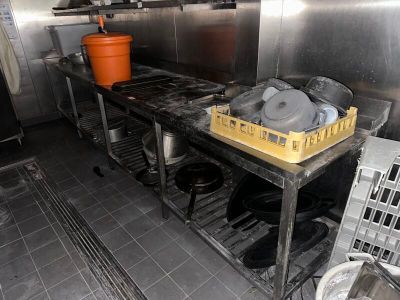 une cuisine équipée d'une cuisinière, d'un évier et d'autres objets posés sur le plan de travail
