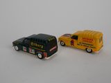 two toy cars that are next to each other on a white surface