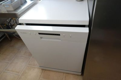 a white dishwasher sitting in a kitchen next to a stove