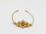 un gros plan d'un bracelet en or orné de fleurs