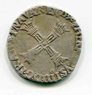 une vieille pièce d'argent sur laquelle figure une croix sur un fond blanc