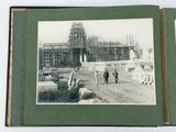 an old photo of a couple of people standing in front of a building under construction