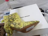 yellow snake skin ankle boots on a white box in a box