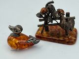 two figurines of animals sitting on top of a table