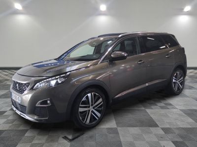 une voiture grise est garée dans une pièce au sol à carreaux