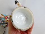 a person holding a small cup with a bird on it