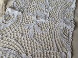 a crocheted table runner on a bed