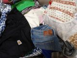 une pile de vêtements posée sur un lit