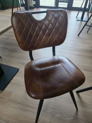 une chaise marron qui se trouve dans une pièce