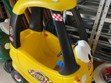 a small yellow toy car with a red hat on top of it