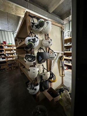 de nombreux casques suspendus à un porte-casques dans une pièce