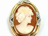 une image représentant le profil d'une femme, sous la forme d'un pendentif camée doré et blanc