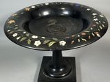 an image of a black plate with flowers and leaves painted on it