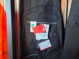 two pairs of pants hanging on a rack in a store