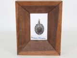 une image représentant un cadre en bois contenant une médaille en argent