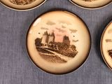 four plates with a picture of a castle on them on a table