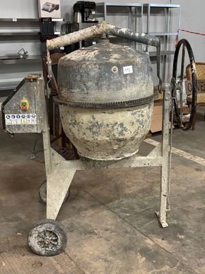 a cement mixer sitting in a garage next to a wall