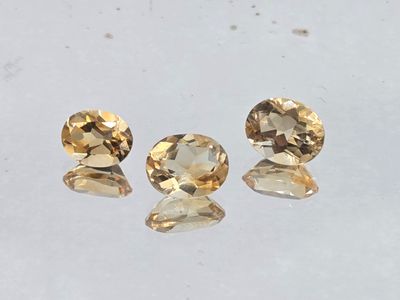 a pair of yellow sapphires sitting on top of a white surface