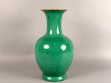 a green vase that is sitting on a table