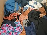 une boîte en carton remplie de vêtements, ainsi que des vêtements éparpillés sur le sol