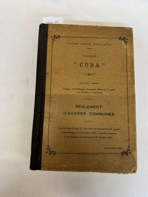 un vieux livre posé sur une table à côté d'une tasse