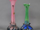 three different colored glass vases sitting next to each other on a gray surface
