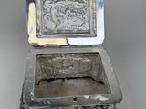 a silver box with a picture on it on a table