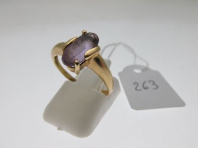 a close up of a ring with a purple stone in it
