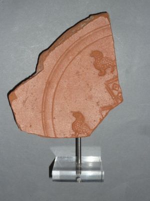 a stone object on a stand on a gray surface
