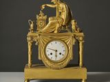 une horloge en or surmontée d'une statue
