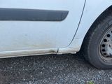 une voiture blanche avec un pneu crevé sur le bord de la route