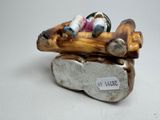 a small figurine of a man and a dog on a log