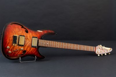 an electric guitar sitting on a stand on a black surface