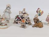 five figurines of people and a dog on a white surface