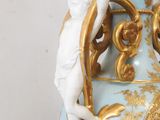 a blue vase with a gold decoration on it