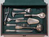 silverware in a green box on a table with a white background