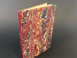 a red and yellow book sitting on top of a black table